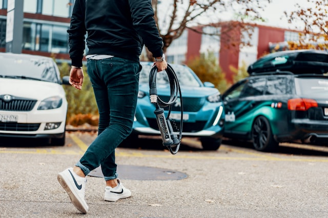 the guy is carrying a charger for an electric car