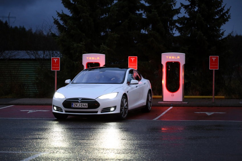 PAIMIO, FINLAND - NOVEMBER 14, 2015: Tesla Model S electric car arrives at the Paimio Tesla Supercharger station at night for charging. Tesla Supercharging stations are open any time.